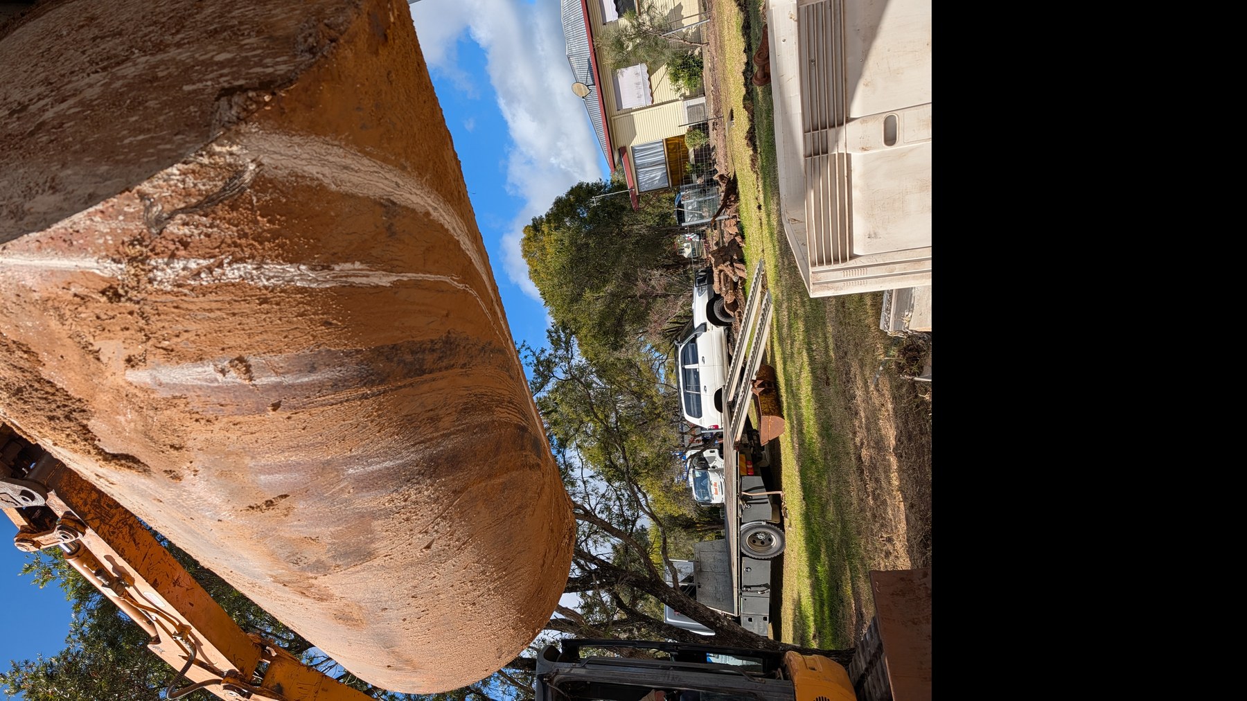 Excavator lifting a decommissioned underground fuel storage tank during UPSS removal and validation at a Crows Nest Queensland investment property